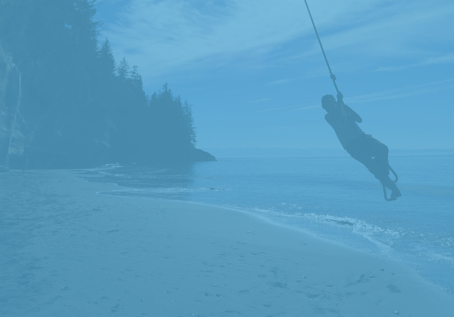 Rope swing over a sandy beach cove on Vancouver Island
